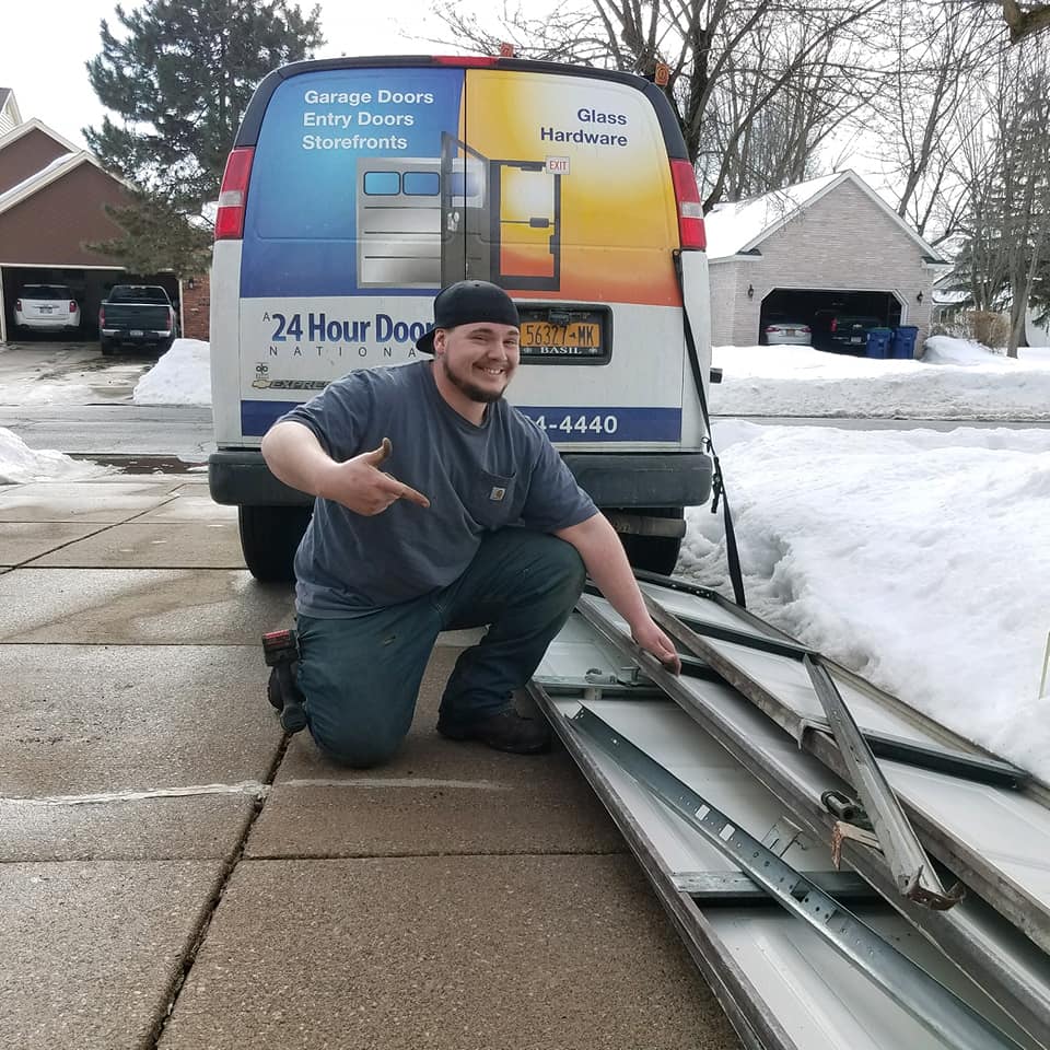 A 24 Hour Door technician pointing at broken garage door