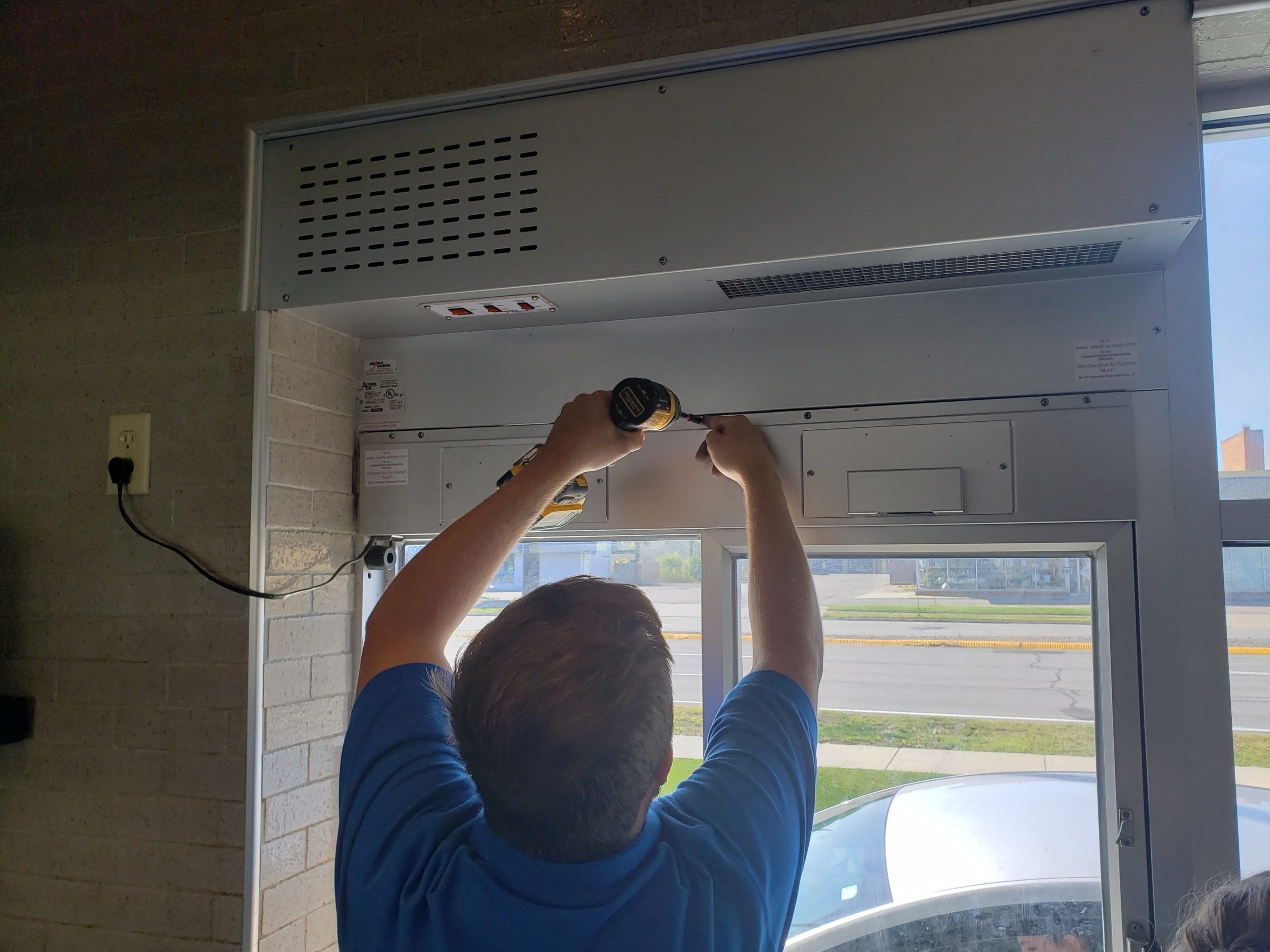 A 24 Hour Door Technician repair drive-thru window at a business